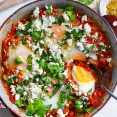 En härlig shakshuka med ägg i tomatsås, toppad med fetaost och koriander. Perfekt för ett smakrikt shakshuka recept.