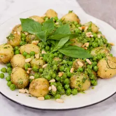 En härlig pesto potatis med gröna ärtor och pinjenötter, toppad med färsk basilika.