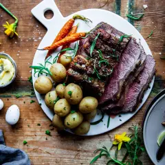 En saftig biff med en härlig kryddig kappa, serverad med småpotatis och morötter. En festlig måltid!
