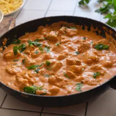 En krämig kycklinggryta i en stekpanna, perfekt för det godaste korv stroganoff receptet. Serveras med ris.