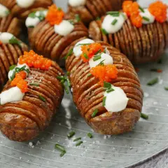 Friterad hasselbackspotatis med klickar av gräddfil, rom och gräslök. En festlig potatisrätt som ser lika god ut som den smakar.