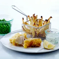 En portion fish and chips med ärtor, citron och remouladsås.
