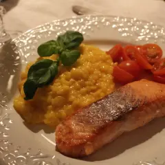 En härlig saffransrisotto med lax, garnerad med färsk basilika och körsbärstomater. En festlig rätt som passar perfekt för alla tillfällen.