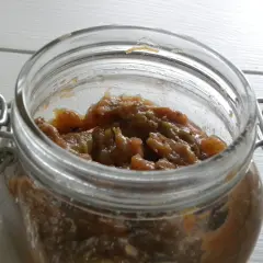 En burk med hemlagad rabarber chutney. Den söta och syrliga chutney passar perfekt till ostbrickan.