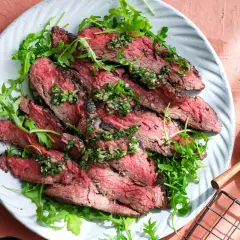 Skivad flapsteak med chimichurri och ruccola, perfekt för ett snabbt och smakrikt flapsteak recept. Serveras med en fräsch tomatsallad.