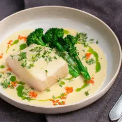 En bit torsk i krämig champagnesås, serverad med broccoli och toppad med örter och rom. En festlig rätt!