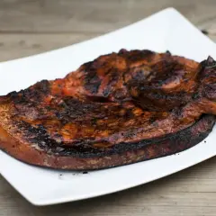Grillad flintastek på en vit tallrik, perfekt tillagad med en härlig yta.