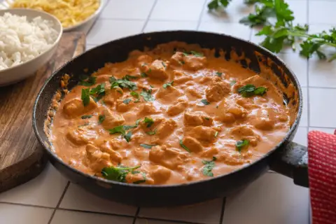 En krämig kycklinggryta i en stekpanna, perfekt för det godaste korv stroganoff receptet. Serveras med ris.