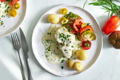 Fiskfilé med krämig dragon sås, små potatisar och tomat- och salladslökssallad. En härlig sommarrätt.