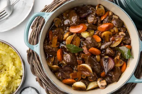 En mustig biff bourguignon i gjutjärnsgryta med möra köttbitar, champinjoner, morötter och lök. Serveras med krämigt potatismos.