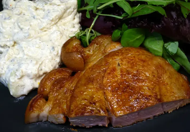 En saftig flintastek i ugn med krämig potatissallad och fräscha gröna blad.