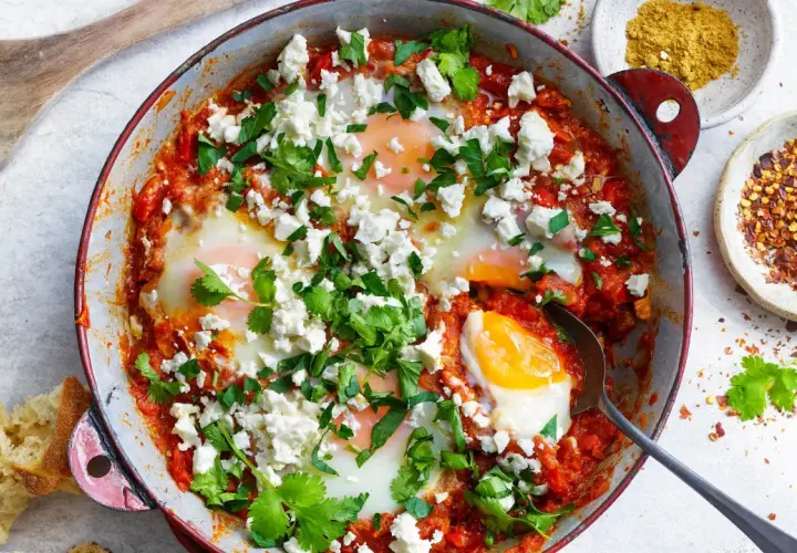En härlig shakshuka med ägg i tomatsås, toppad med fetaost och koriander. Perfekt för ett smakrikt shakshuka recept.