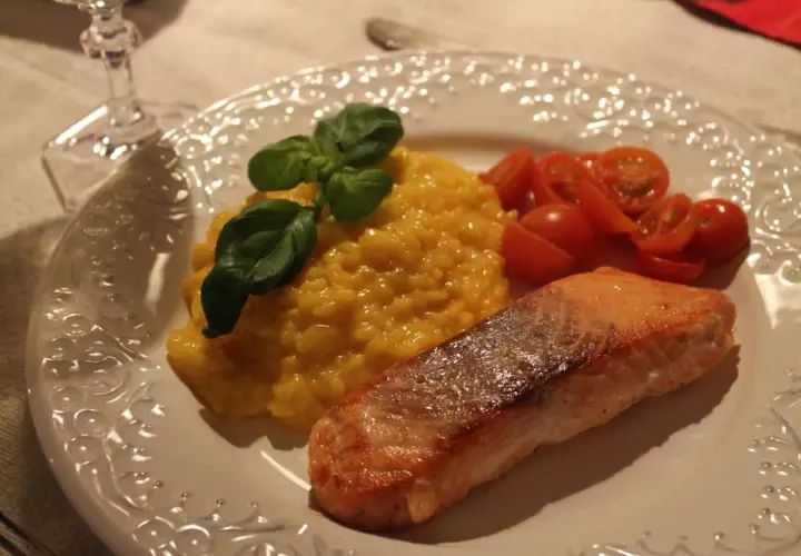 En härlig saffransrisotto med lax, garnerad med färsk basilika och körsbärstomater. En festlig rätt som passar perfekt för alla tillfällen.