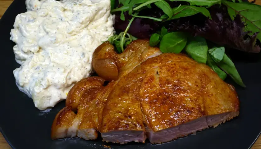 En saftig flintastek i ugn med krämig potatissallad och fräscha gröna blad.