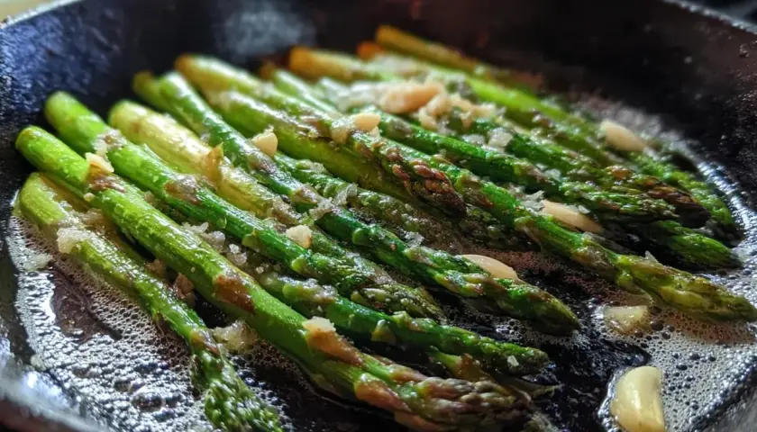 Grön sparris steks i en gjutjärnspanna med vitlök. Ett enkelt sparris recept som passar till det mesta.