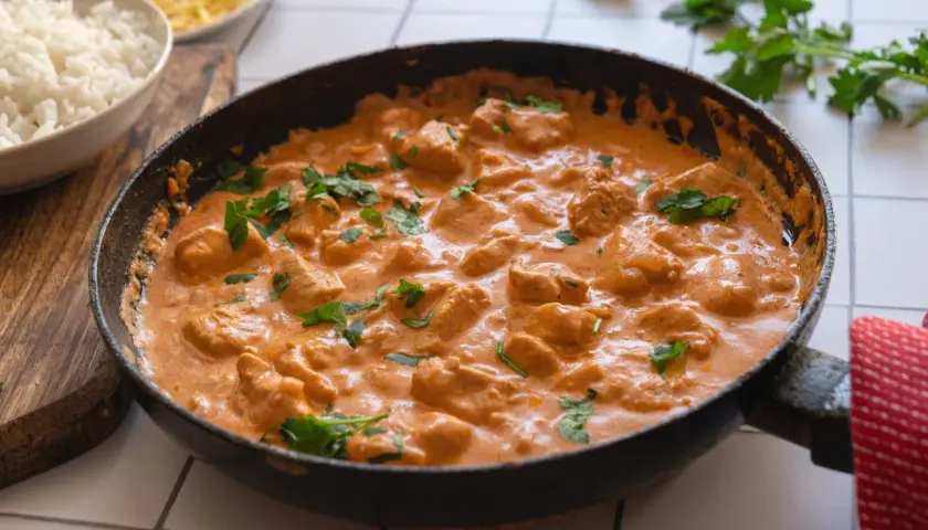 En krämig kycklinggryta i en stekpanna, perfekt för det godaste korv stroganoff receptet. Serveras med ris.