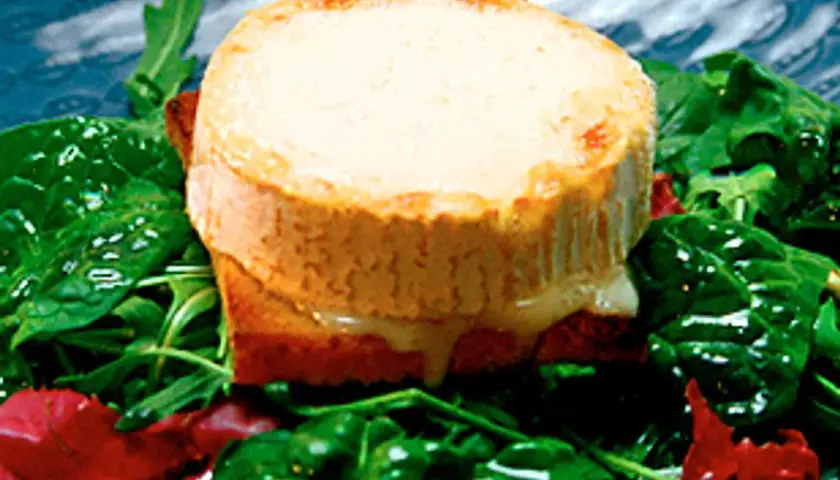 Varm chevre på rostat bröd med gröna blad och röda inslag. Ett enkelt och gott chevre recept.