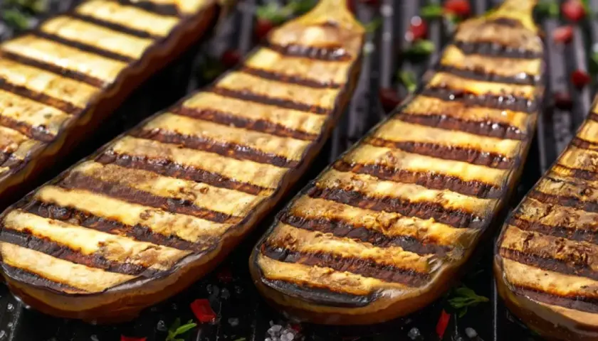 Grillade aubergines med vackra grillränder, redo att serveras. Perfekt för en somrig middag.