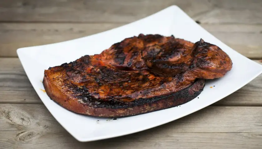 Grillad flintastek på en vit tallrik, perfekt tillagad med en härlig yta.
