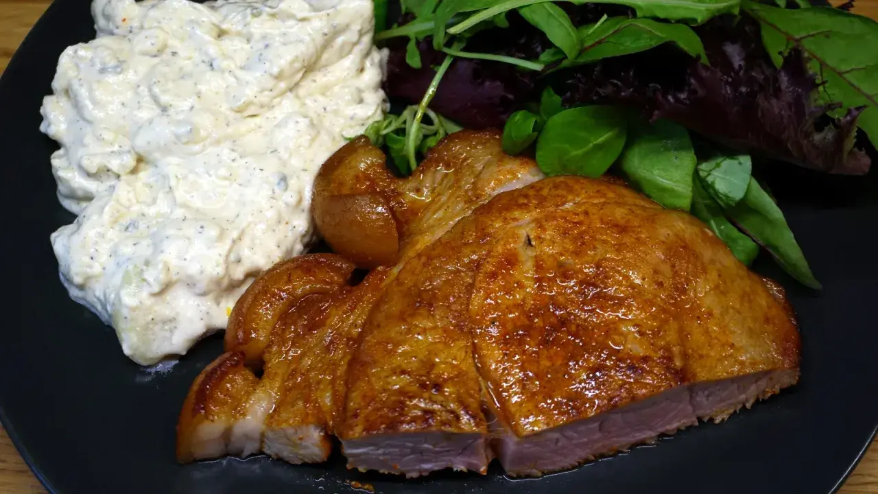 En saftig flintastek i ugn med krämig potatissallad och fräscha gröna blad.