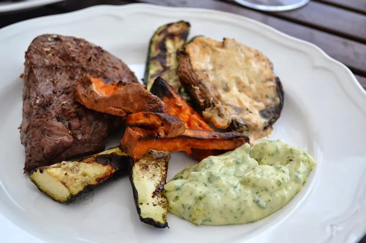 En saftig biff med grillade grönsaker, sötpotatis och en krämig sås. Perfekt för en sommarkväll med grillad portabello.