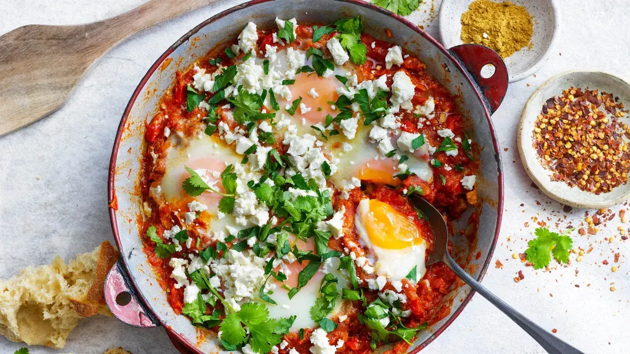 En härlig shakshuka med ägg i tomatsås, toppad med fetaost och koriander. Perfekt för ett smakrikt shakshuka recept.