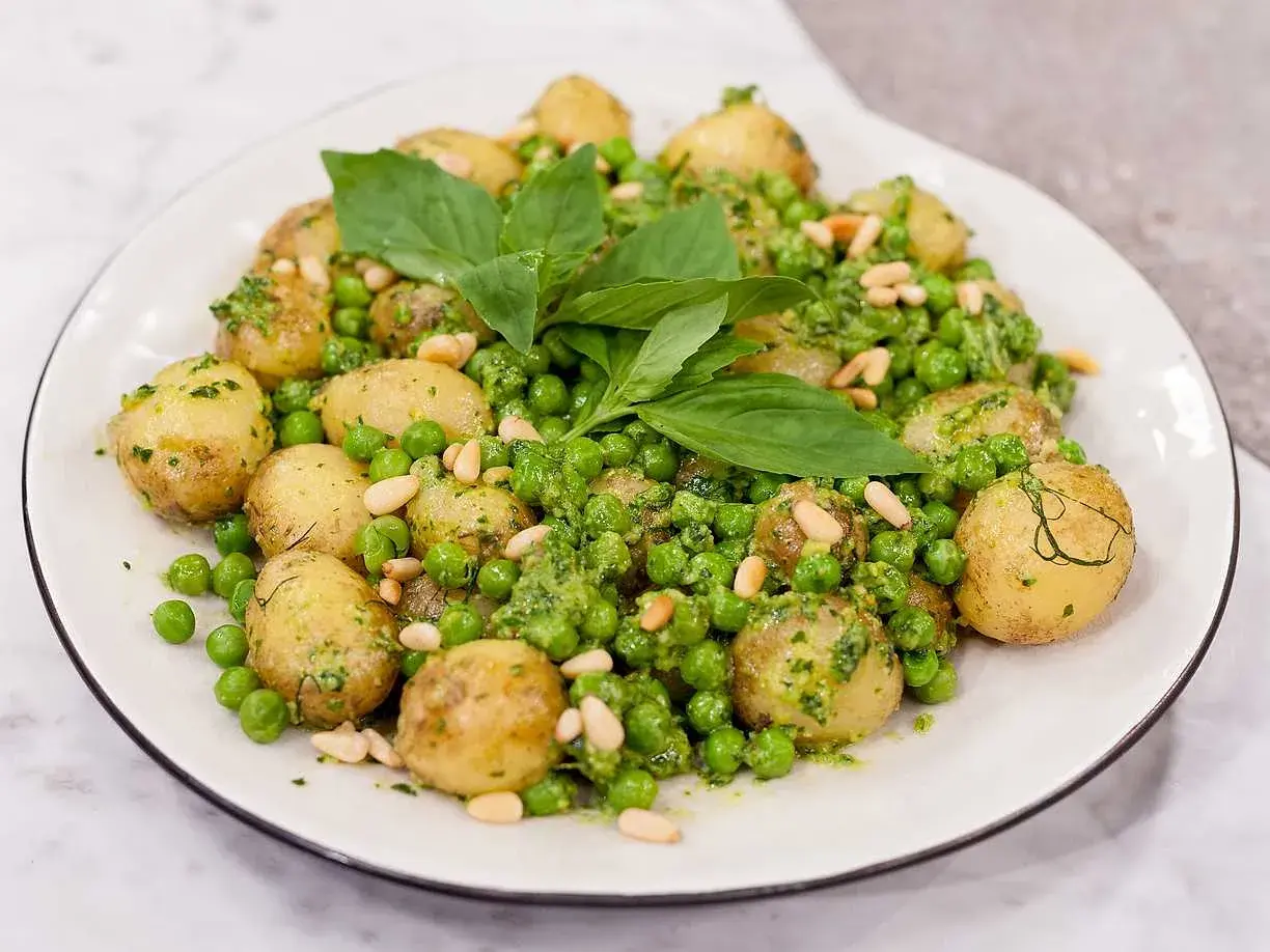 En härlig pesto potatis med gröna ärtor och pinjenötter, toppad med färsk basilika.