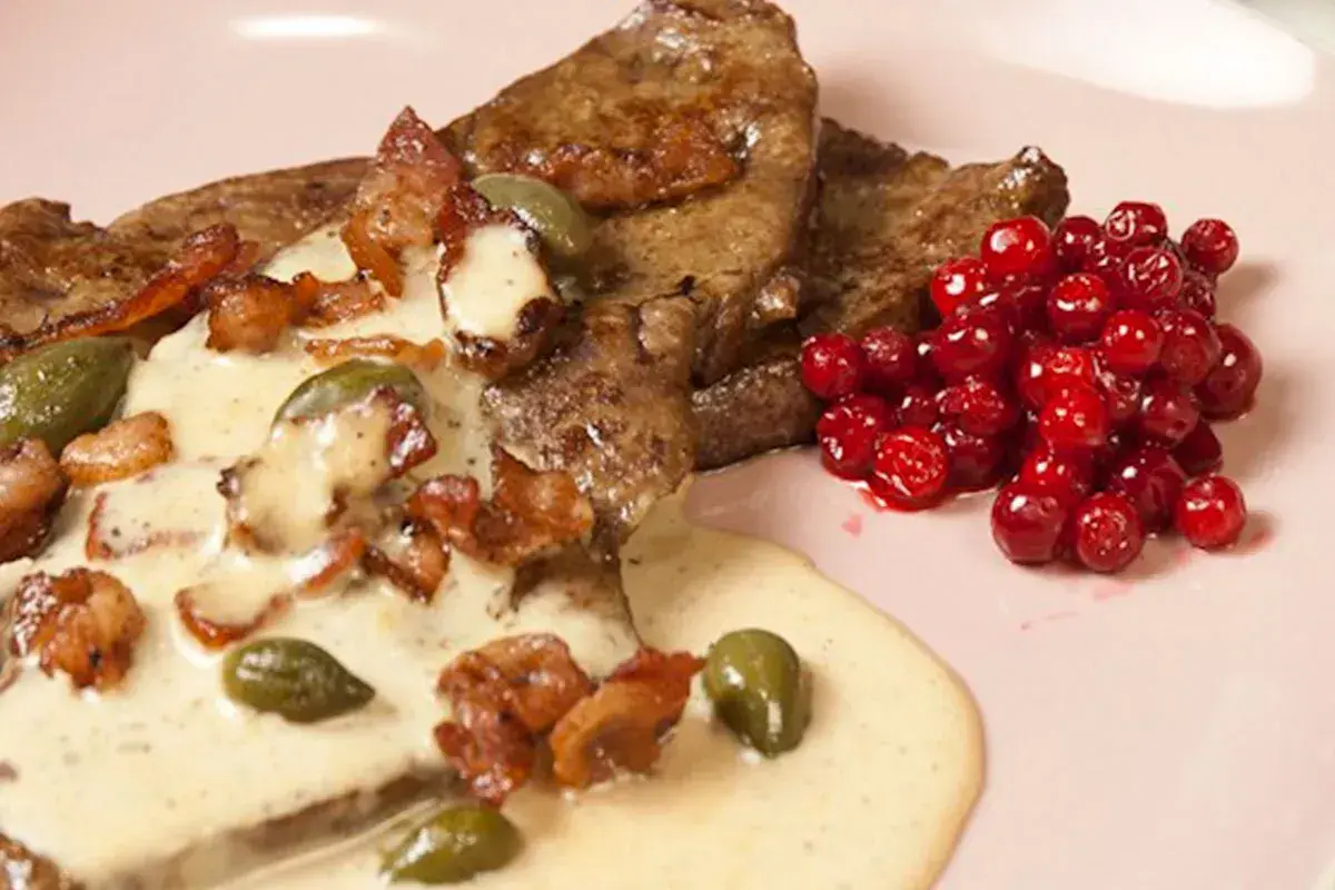 Stekt lever med krämig sås, knaperstekt bacon, kapris och rårörda lingon. Ett klassiskt lever recept.