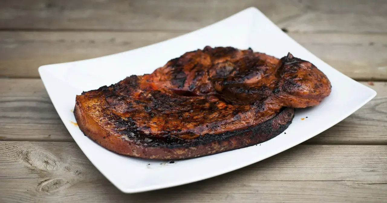 Grillad flintastek på en vit tallrik, perfekt tillagad med en härlig yta.