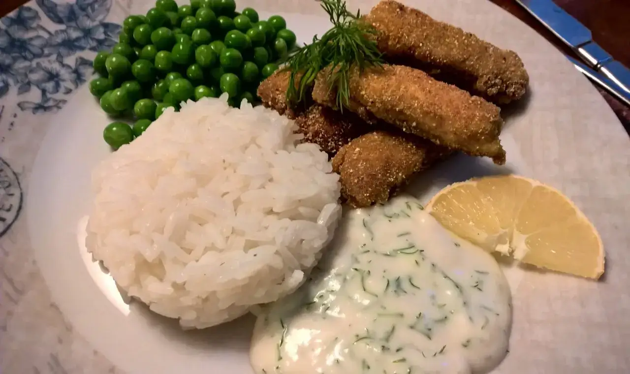 Panerad fisk, ris, &auml;rtor och en klick kr&auml;mig dills&aring;s varm. En citronskiva f&ouml;r extra fr&auml;sch&ouml;r.