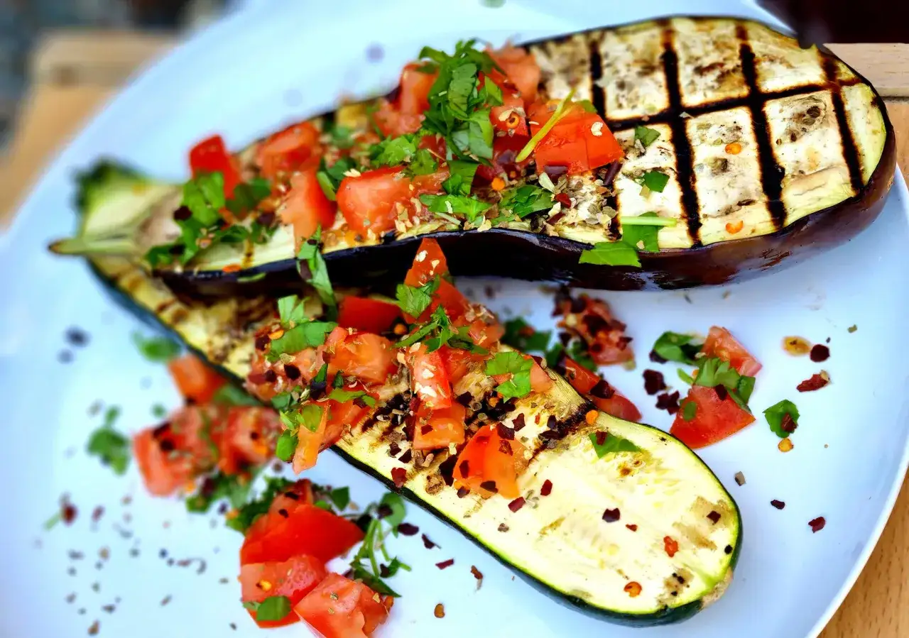 Grillad aubergine toppad med f&auml;rska tomater och &ouml;rter. En h&auml;rlig sommarr&auml;tt som passar perfekt till grillkv&auml;llen.