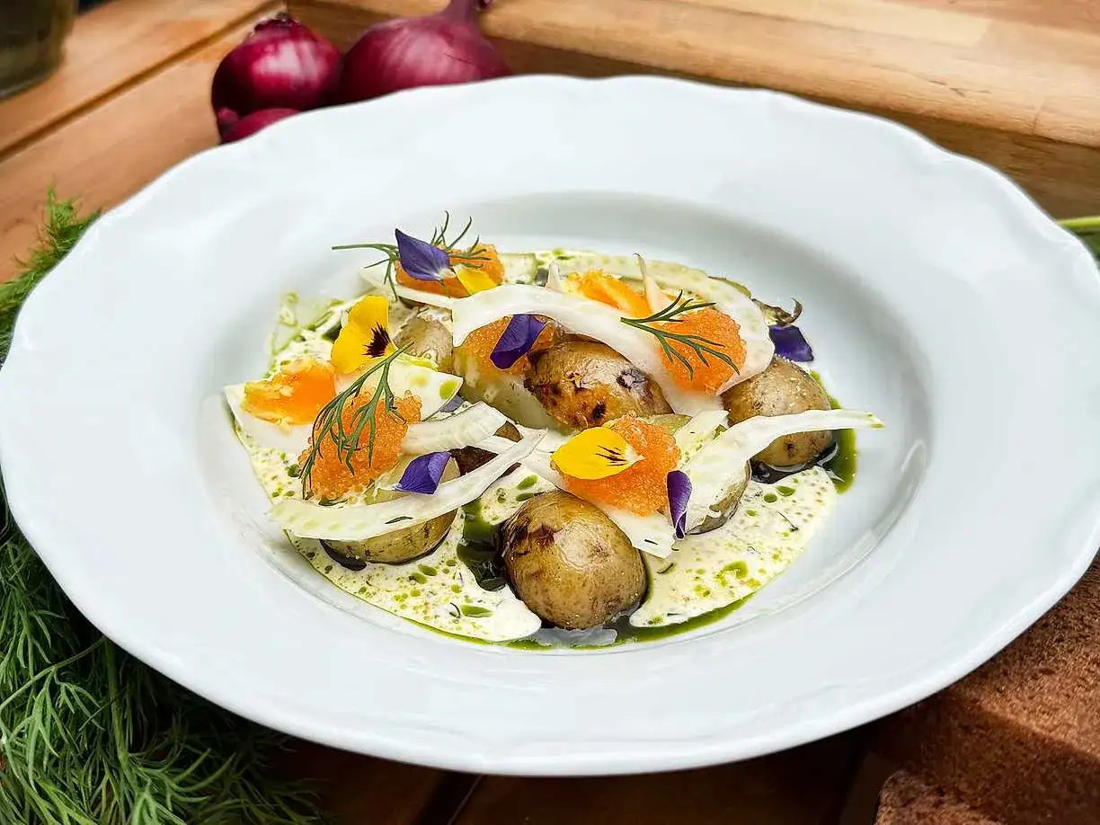 Välkokta småpotatisar med fänkål, ägg, rom och dill i en krämig sås. Vackert dekorerad med blommor och örter.