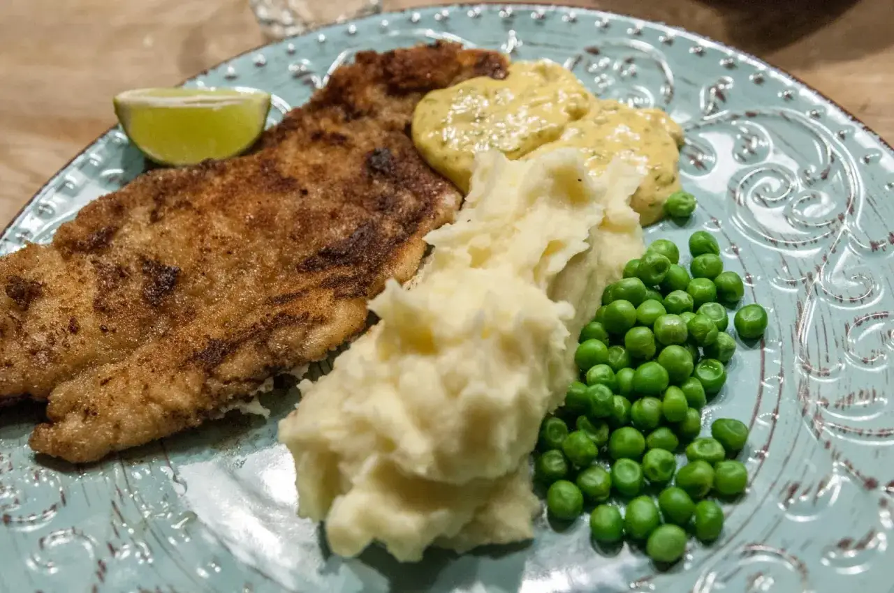 Panerad fisk med potatismos, gröna ärtor, lime och en klick egen remouladsås.