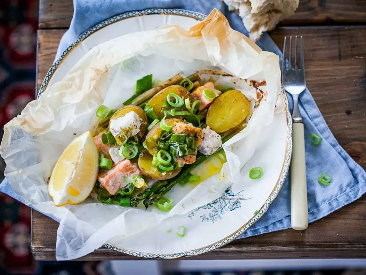 En smaklig fiskpaket p&aring; grillen med lax, potatis, sparris och citron.