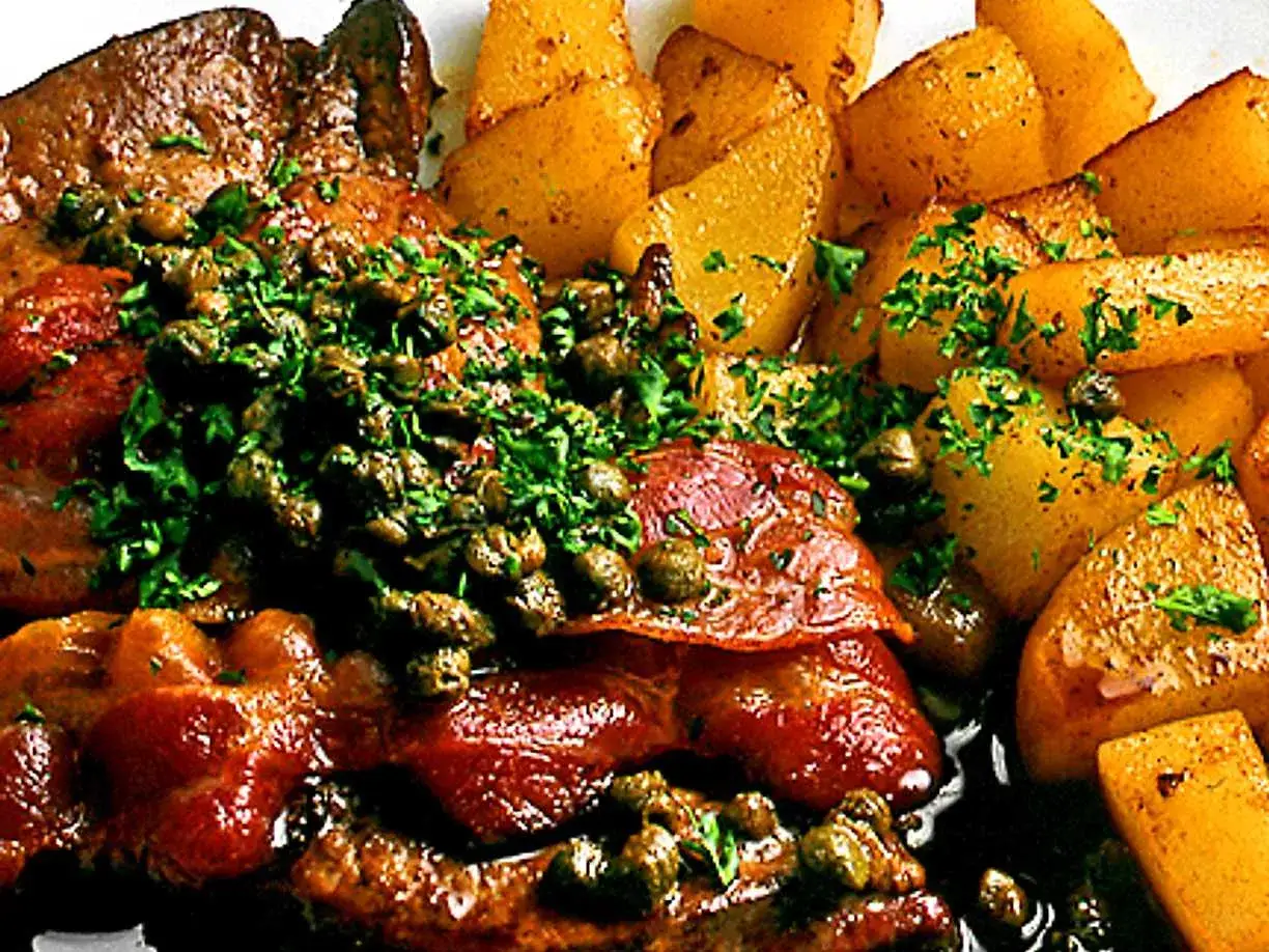 Stekt lever med kapris och persilja, serverad med ugnsrostade potatisklyftor. Ett klassiskt lever recept som är lätt att laga.