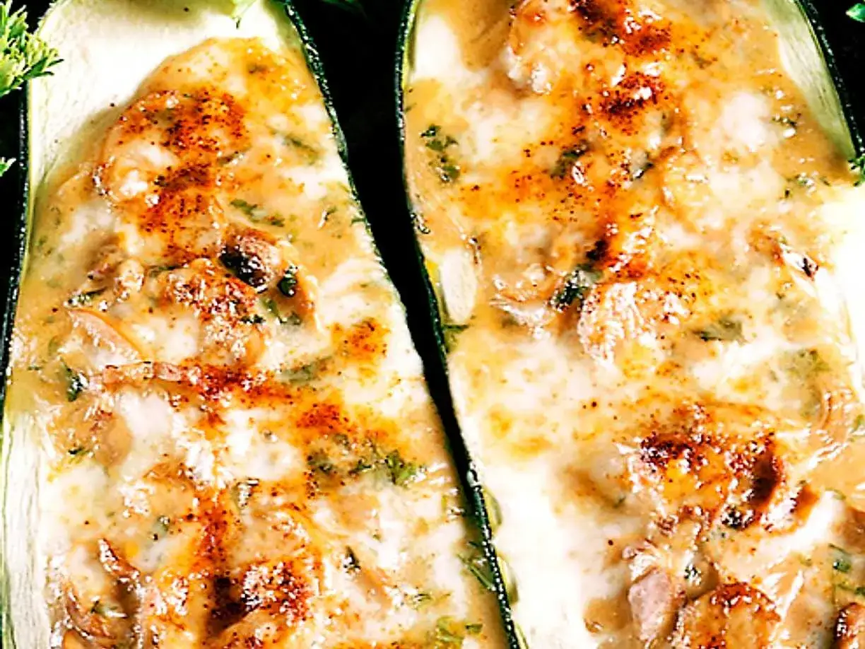 Tv&aring; halvor av fylld zucchini med en kr&auml;mig, gyllene fyllning och str&ouml;ssel av kryddor.