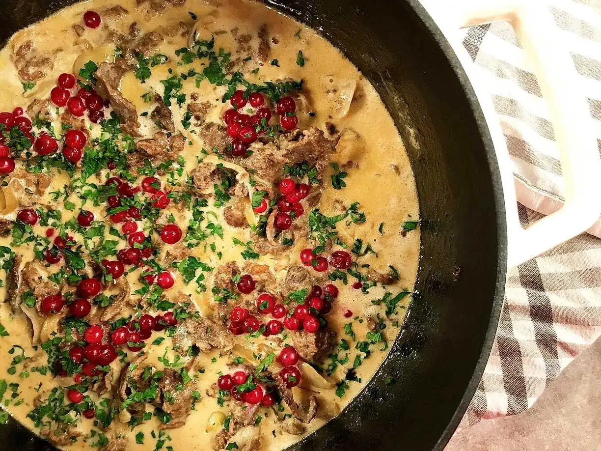 Krämig renskav med lingon och persilja i gjutjärnspanna. Ett klassiskt renskav recept som är perfekt till middag.