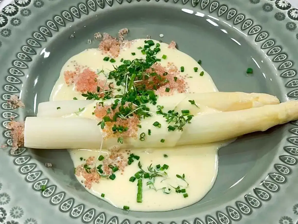 Vit sparris i en kr&auml;mig s&aring;s, toppad med rosa rom och f&auml;rska &ouml;rter. En delikatess som f&ouml;r tankarna till v&aring;rens f&ouml;rsta skott.