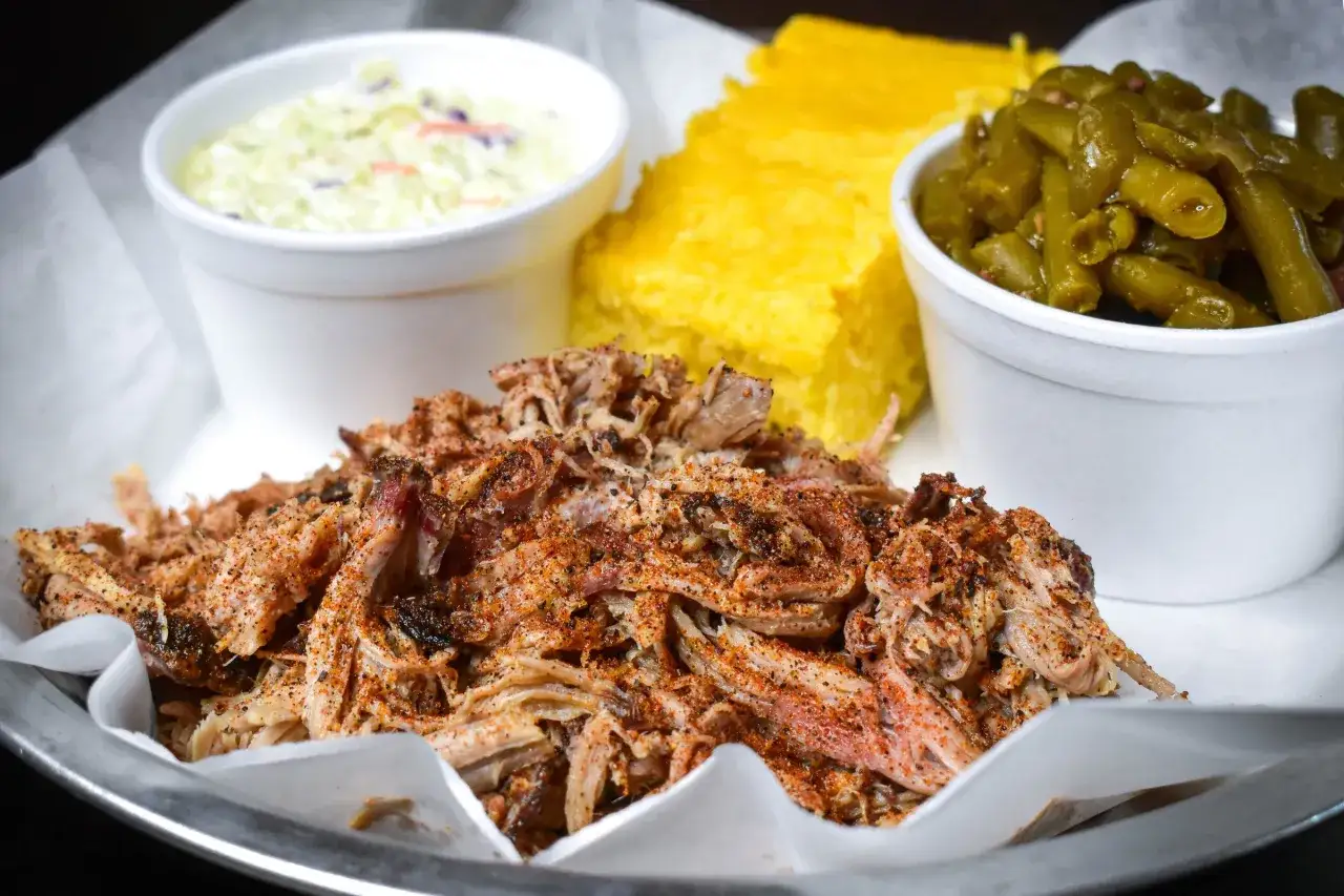 En tallrik med saftig pulled pork, majsbröd, coleslaw och gröna bönor. Perfekt sås till pulled pork.