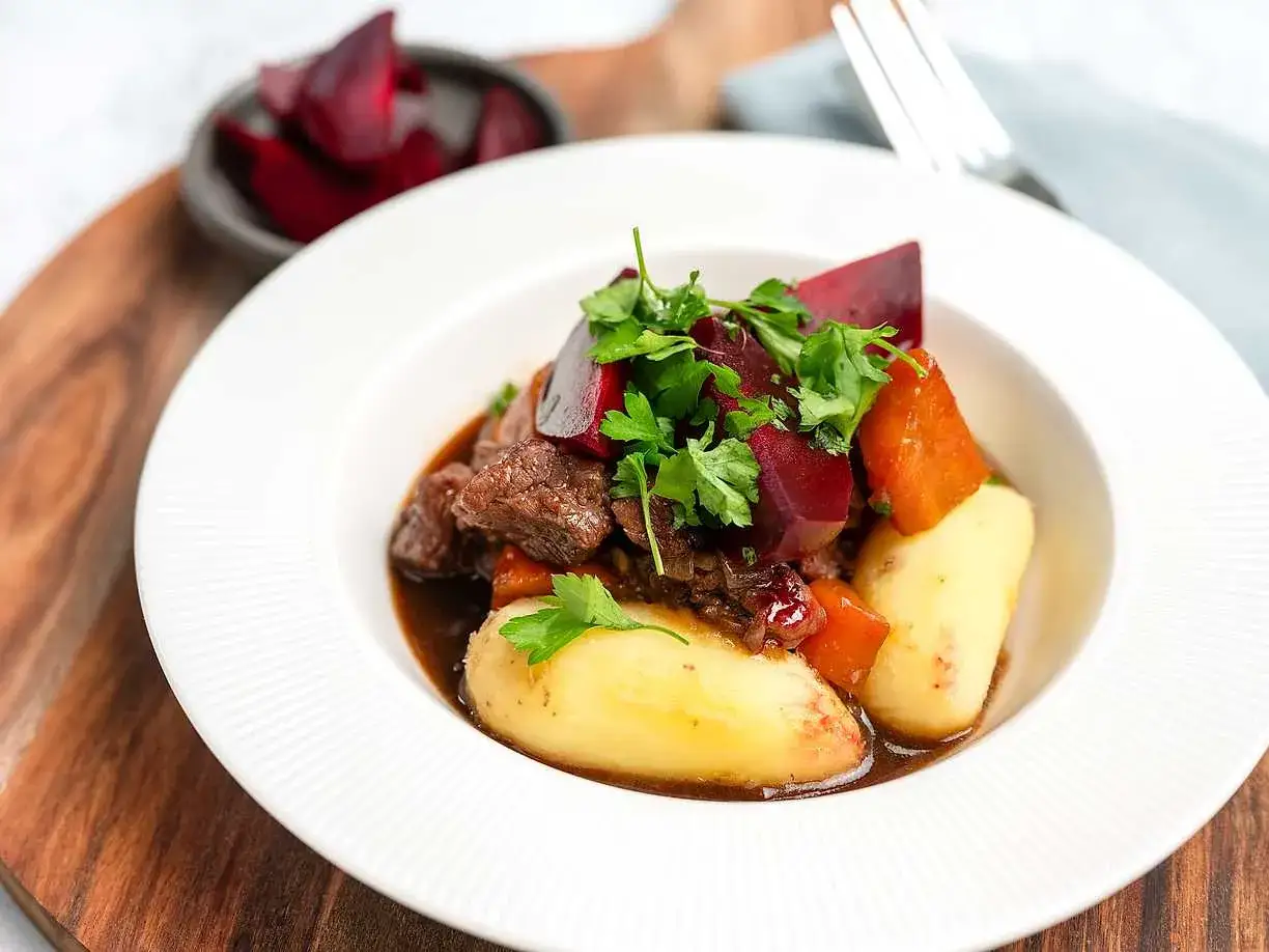 En tallrik med mustig kalops, potatis och rödbetor, perfekt för ett klassiskt kalops recept.