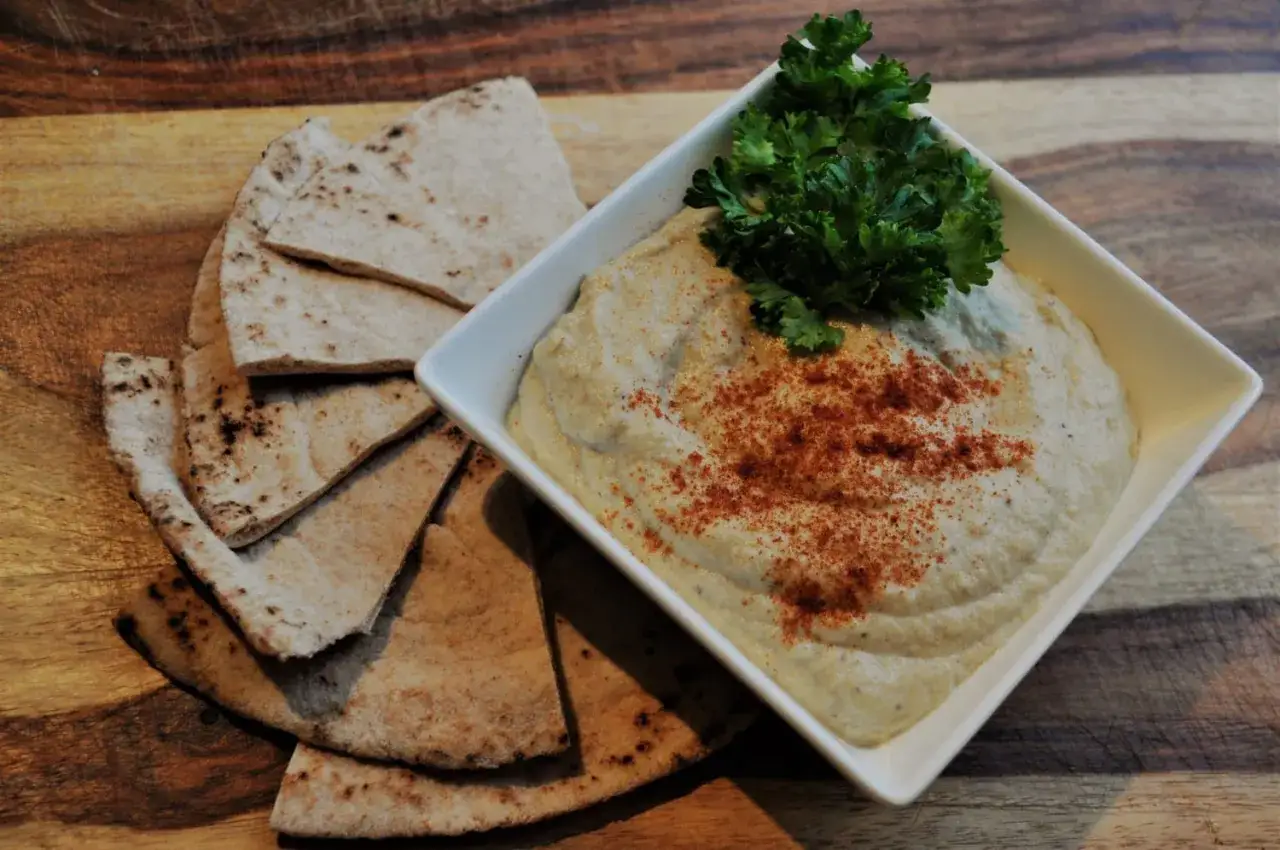 Krämig baba ganoush med pitabröd och persilja, redo att avnjutas.