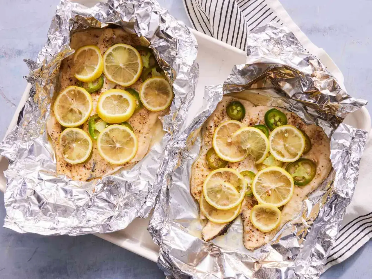Tv&aring; portioner fisk i folie, toppade med citronskivor och jalape&ntilde;o. Enkel och god middag!